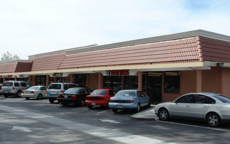 Single-storey neighbourhood retail strip with surface parking